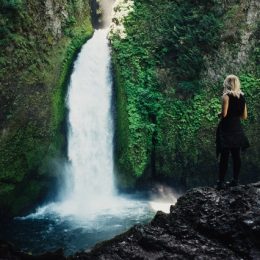 Woman standing in front of a waterfall