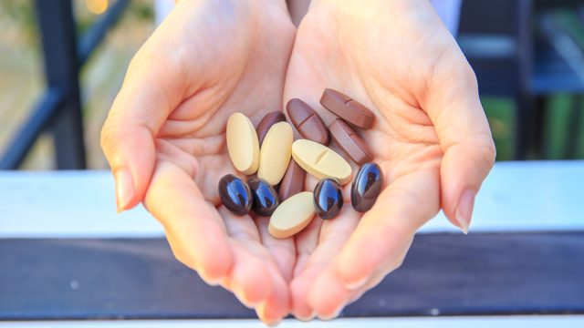Woman holds vitamins in her hand