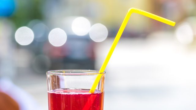 Picture of a red drink with straw.