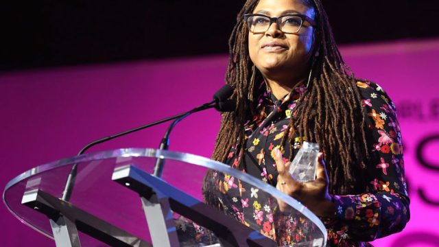 Ava DuVernay speaking at podium onstage at the 2017 ESSENCE Festival