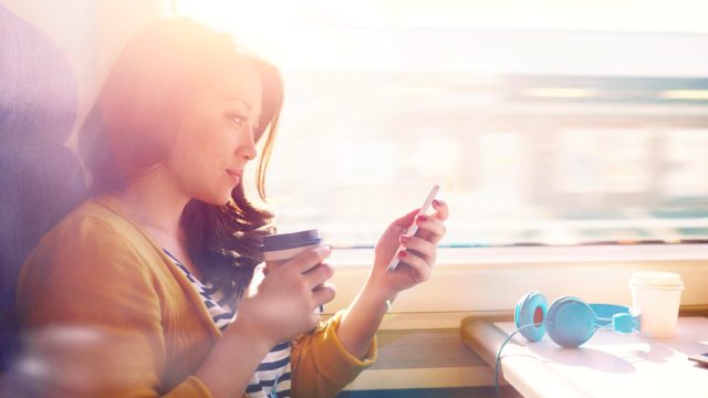 Girl looking at phone on train.