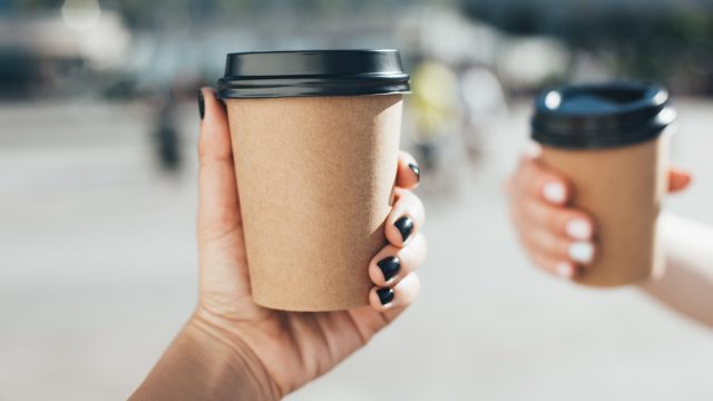 People cheersing with coffee cups.