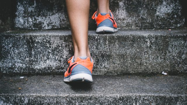 back view of runner's shoes sprinting up stairs