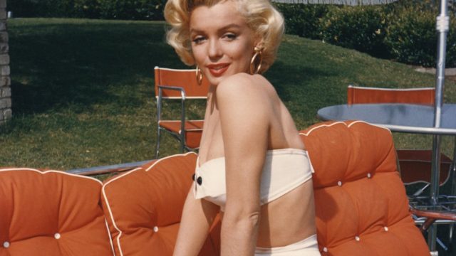 Actress Marilyn Monroe poses for a portrait in a two-piece swimsuit