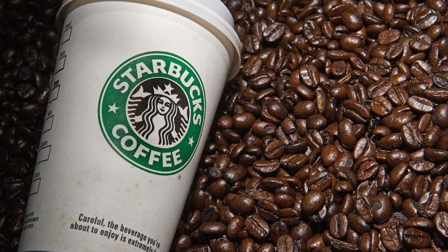 A Starbucks coffee cup and coffee beans