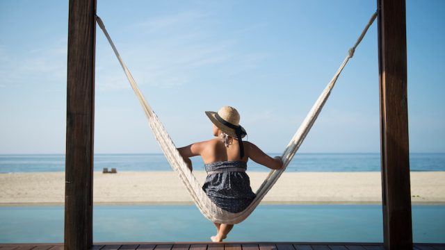 Woman sitting on a hammock on the coast of Mexico