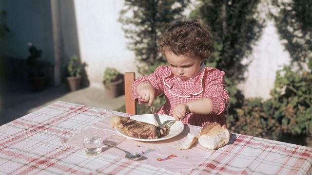 9/1951-Argentina: Plentiful meat situation. Men cooking with crude cooking device.