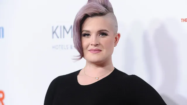 Kelly Osbourne wears a purple updo and black top on the red carpet