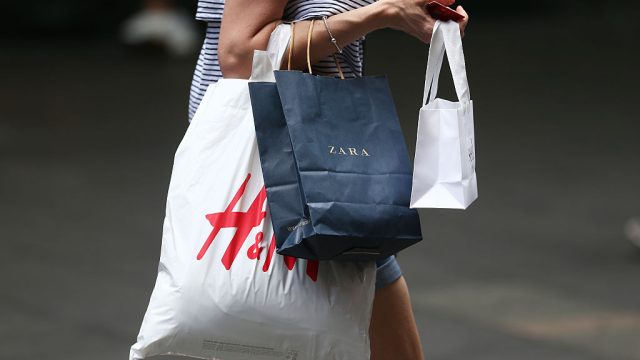 A shopper carries shopping bags by Zara, operated by Inditex SA, and Hennes & Mauritz AB (H&M) in Sydney, Australia, on Saturday, Dec. 10, 2016. Australia is scheduled to release consumer confidence data on Dec. 14. Photographer: Brendon Thorne/Bloomberg via Getty Images