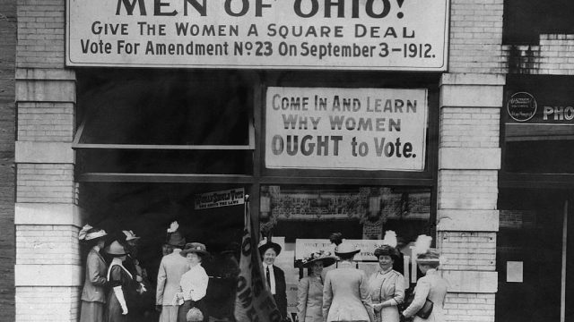 1912-Cleveland, OH: Photo of the Headquarters of women voters on upper Euclid Avenue in Cleveland. Holding the flag for suffagists is Miss Belle Sherwin, president of the organization.