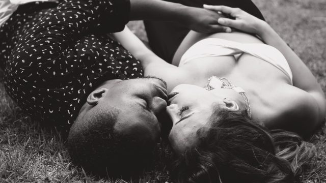 Couple-face-to-face-lying-on-ground