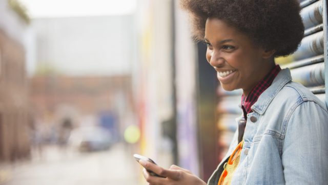 Woman using cell phone on city street