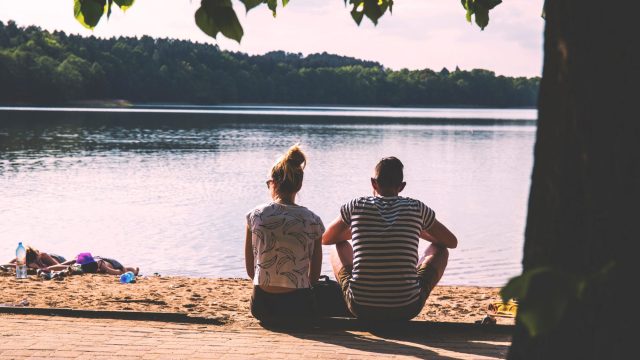 couple-sitting-by-lake