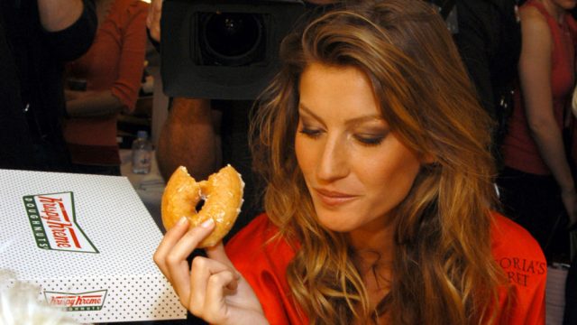 Gisele Bundchen eats a Krispy Kreme donut during 9th Annual Victoria's Secret Fashion Show - Hair and Makeup at The New York State Armory in New York City, New York, United States. (Photo by Jason Nevader/WireImage for Full Picture)