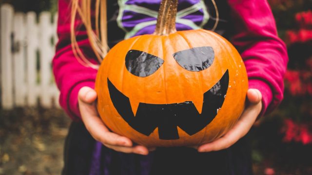 child-holding-decorated-pumpkin