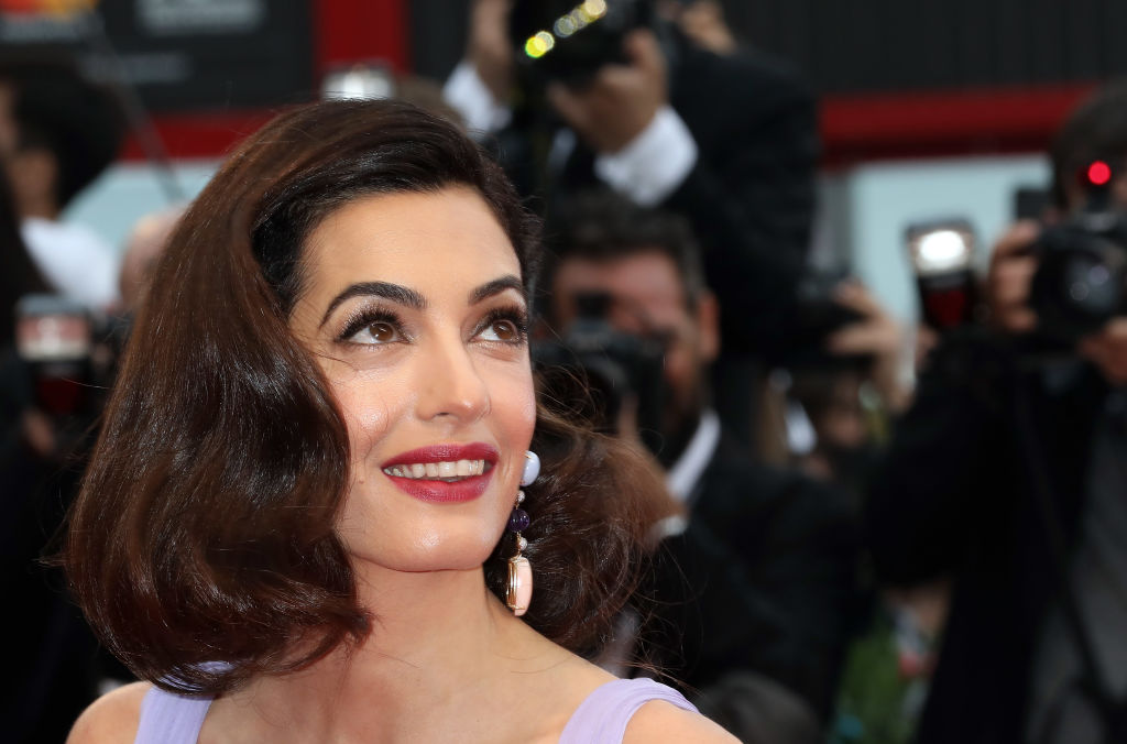 Amal Clooney dazzles in gold dress – and George can't take his