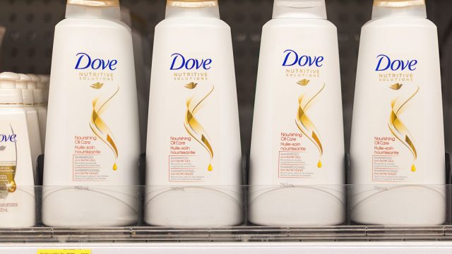 Dove shampoo and conditioner bottles in a shelf. Dove is one