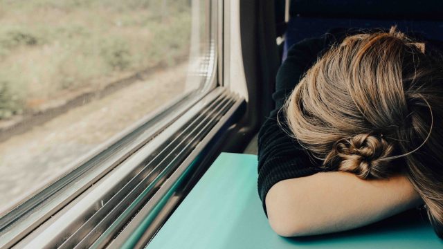 woman-sleeping-on-train-window