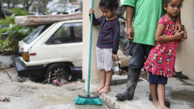 JAYUYA, PUERTO RICO – OCTOBER 09: Young members of the Timoral family stand in front of their damaged home, with no running water or electricity, more than two weeks after Hurricane Maria hit the island, on October 9, 2017 in Jayuya, Puerto Rico. Only 15 percent of Puerto Rico’s electricity has been restored. Puerto Rico experienced widespread damage including most of the electrical, gas and water grid as well as agriculture after Hurricane Maria, a category 4 hurricane, swept through. (Photo by Mario Tama/Getty Images)