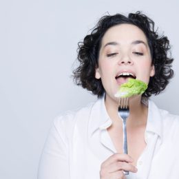Woman eating lettuce off fork