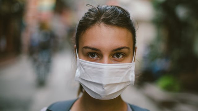 Young woman wearing face mask in the street.