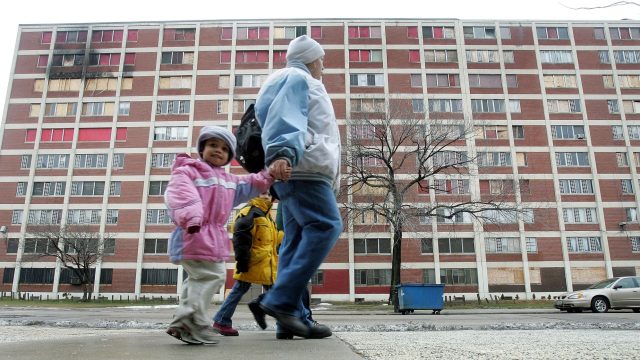 CHICAGO - JANUARY 12: Residents walk past one of the few remaining Chicago Housing Authority Cabrini-Green public housing buildings January 12, 2005 in Chicago, Illinois. The run-down and dilapidated buildings sit on prime real-estate property that the city of Chicago wants to tear down and redevelop. At one time, the CHA's Cabrini-Green development had 22 high-rise buildings on 70 acres of land with 3,500 apartment units housing approximately 15,000 residents. (Photo by Tim Boyle/Getty Images)