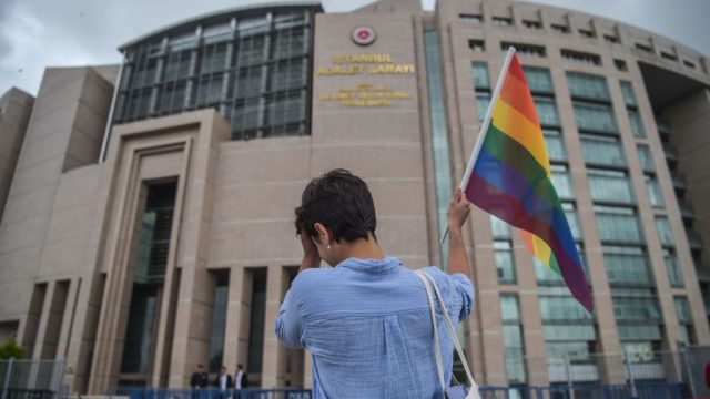 A person waves a rainbow flag in front of Istanbul courthouse on June 19, 2017 in support to eleven LBTG activists who went on trial.