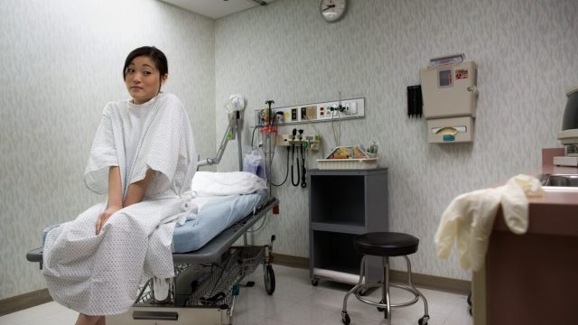 Low angle view of a young woman sitting on an examination table