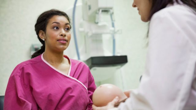 oung female patient listening to doctor's explanation using breast model