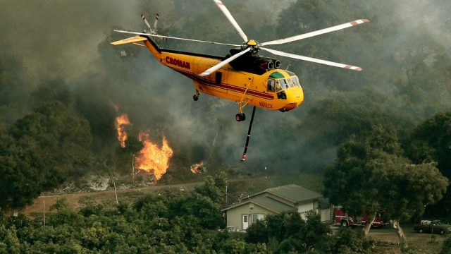 Firefighting helicopters try to save a house from the Thomas wildfire in Carpinteria, California
