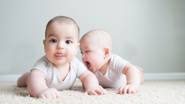 Fraternal twin boys cheerfully play with each other baby names