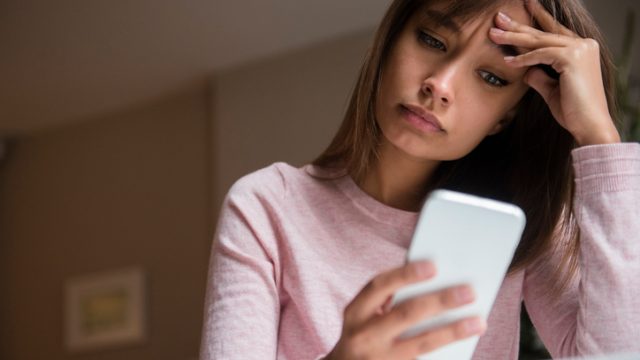 Frustrated Mixed Race woman texting on cell phone anxiety