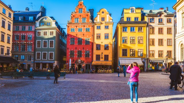 A tourist photographing the iconic buldings at Stortorget.