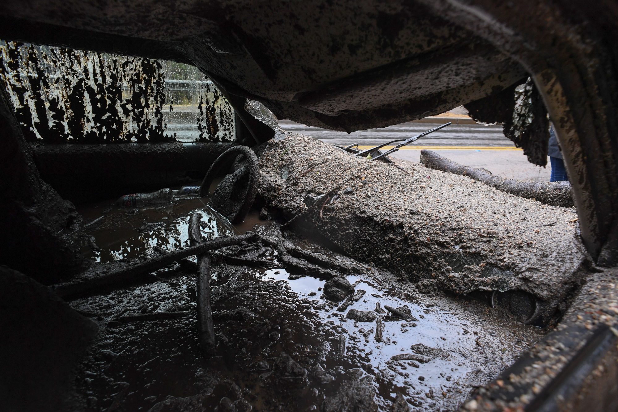 TOPSHOT - Mud fills the interior of a car destroyed in a rain-driven mudslide in a neighborhood under mandatory evacuation in Burbank, California, January 9, 2018.                      Mudslides unleashed by a ferocious storm demolished homes in southern California, authorities said Tuesday. Five people were reported killed.