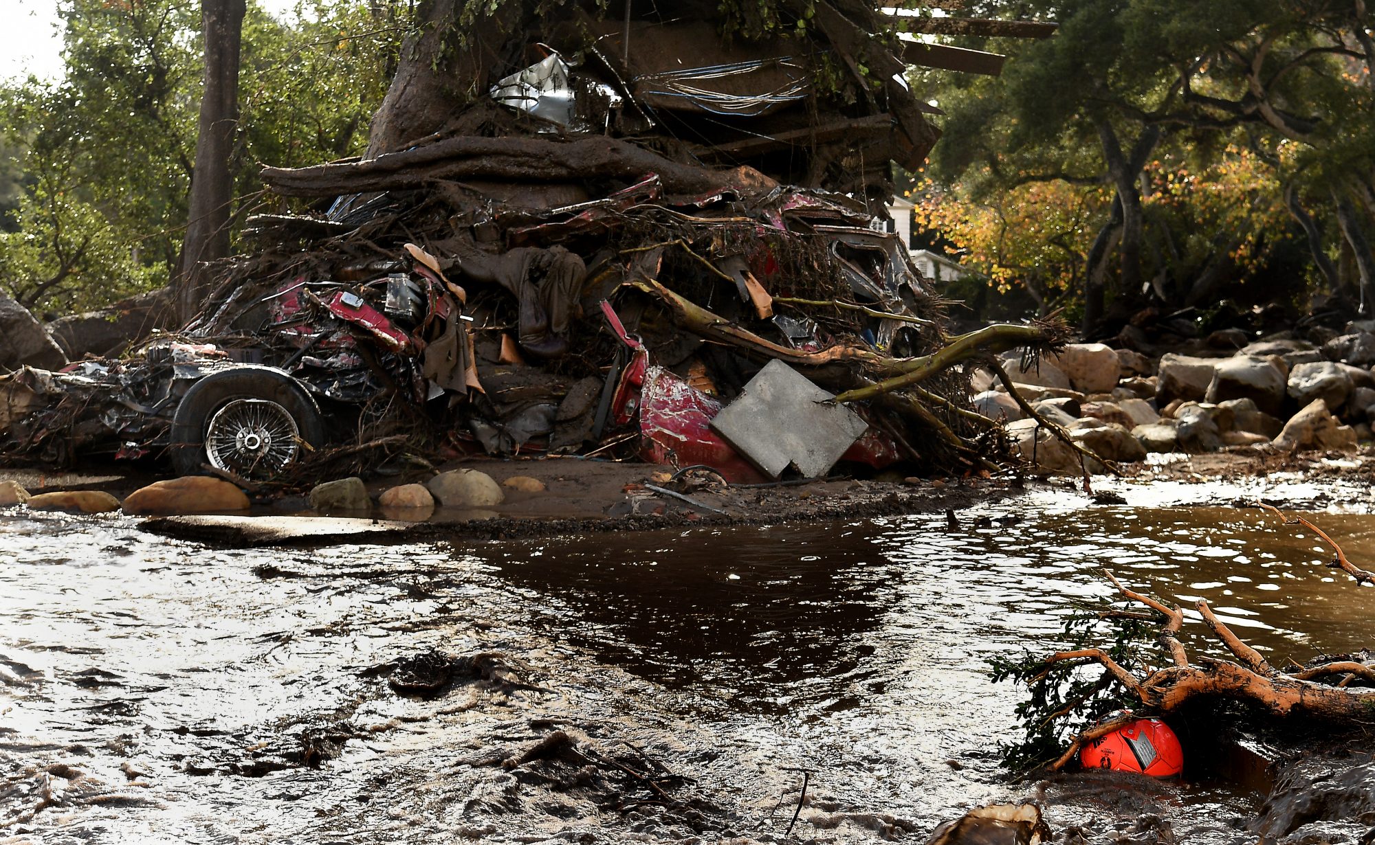 MONTECITO, CA - JANUARY 9: A mangled car along with other debris stack up aguainst a tree along Hot Springs Road in Montecito after a major storm hit the burn area Tuesday January 9, 2018 in Montecito, California.