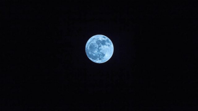 Blue moon in dark sky and far from earth
