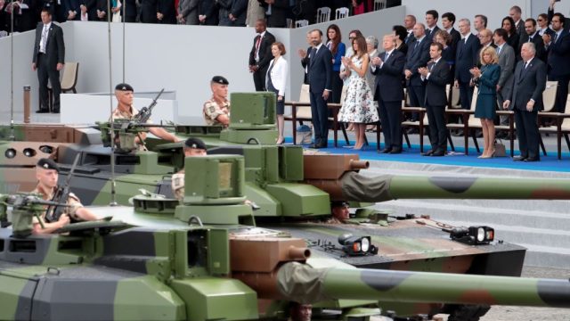 Bottom row, from R) French President and Senate President Gerard Larcher, wife of French President Brigitte Macron, French President Emmanuel Macron, US President Donald Trump, US First Lady Melania Trump, French Prime Minister Edouard Philippe and French Defence Minister Florence Parly look at members of the 5e Regiment de Cuirassiers ride by in tanks as they attend the annual Bastille Day military parade on the Champs-Elysees avenue in Paris on July 14, 2017. The parade on Paris's Champs-Elysees will commemorate the centenary of the US entering WWI and will feature horses, helicopters, planes and troops. / AFP PHOTO / joel SAGET (Photo credit should read JOEL SAGET/AFP/Getty Images)