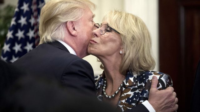 U.S. President Donald Trump greets Betsy DeVos, U.S. secretary of education, right, during an event for School Choice in the Roosevelt Room at the White House in Washington, D.C., U.S., on Wednesday, May 3, 2017. Trump welcomed Palestinian Authority leader Mahmoud Abbas to the White House on Wednesday as the U.S. president weighs how to approach a Middle East conflict that has eluded resolution for seven decades. Photographer:
