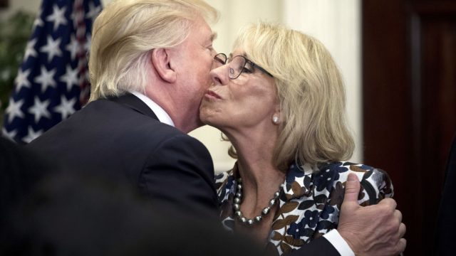U.S. President Donald Trump greets Betsy DeVos, U.S. secretary of education, right, during an event for School Choice in the Roosevelt Room at the White House in Washington, D.C., U.S., on Wednesday, May 3, 2017. Trump welcomed Palestinian Authority leader Mahmoud Abbas to the White House on Wednesday as the U.S. president weighs how to approach a Middle East conflict that has eluded resolution for seven decades. Photographer: