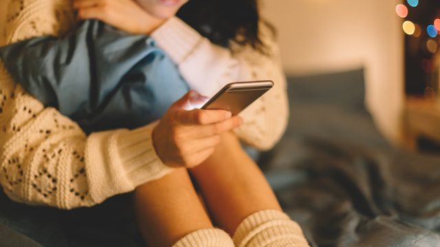 Girl in bed using phone