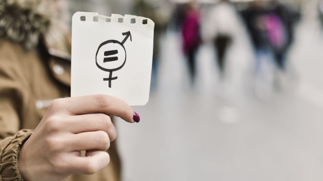Image of woman holding equality sign