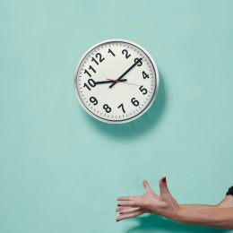 Woman's hands throws a Wall clock in the air