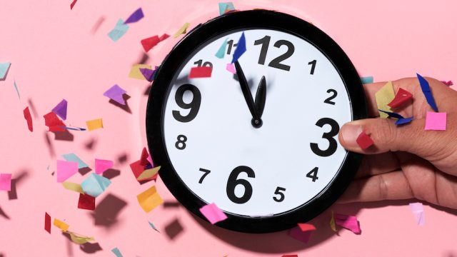 confetti of different colors falling over a clock