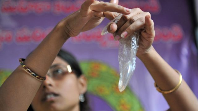 Indian programme officer G. Shilpa poses with a female condom at an awareness camp for sex workers in Hyderabad on March 27, 2010, held to acheive better prevention of Sexually Transmitted Diseases (STD) among sex workers. Integrated Rural Development Services (IRDS) in association with The Andhra Pradesh state AIDS Control Society (APSACS) are implementing targeted interventions among sex workers in the southern Indian state of Andhra Pradesh with an overall goal to halt and reverse the spread of the HIV/AIDS epedemic by 2012. AFP PHOTO/Noah SEELAM (Photo credit should read NOAH SEELAM/AFP/Getty Images)