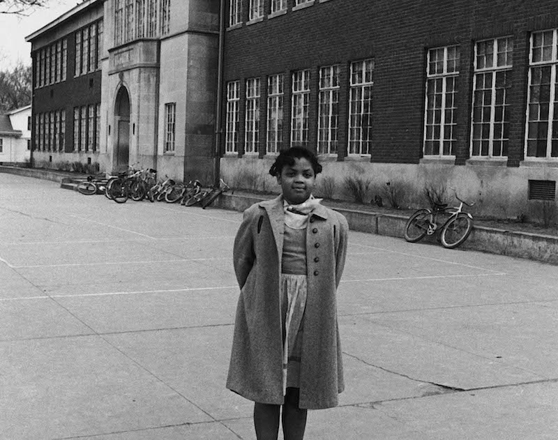 Linda Brown in front of segregated Monroe Elementary School which she attends.