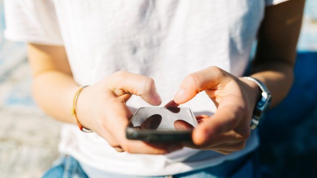 Close-up of woman text messaging