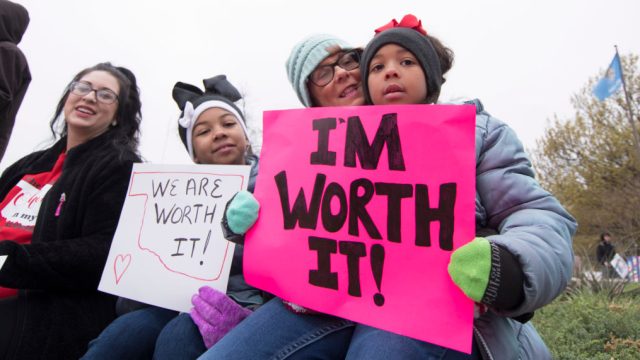OKLAHOMA CITY, OK - APRIL 2: Natalie Armstrong (left) and her two daughters Payton and Pazyzlrn, along with her mother rally at the state capitol in Oklahoma City, Oklahoma on April 2, 2018. Thousands of teachers and supporters are scheduled to rally Monday at the state Capitol as Oklahoma becomes the latest state to be plagued by teacher strife. Armstrong said she has spent $3,000 this year for school supplies Teachers are walking off the job after a $6,100 pay raise was rushed through the Legislature and signed into law by Gov. Mary Fallin. (Photo by J Pat Carter/Getty Images)