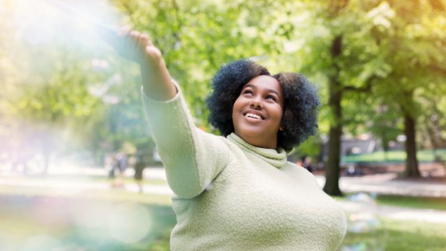 Woman playing with bubbles in a park