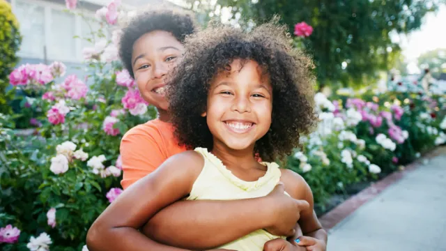Mixed Race brother hugging sister outdoors