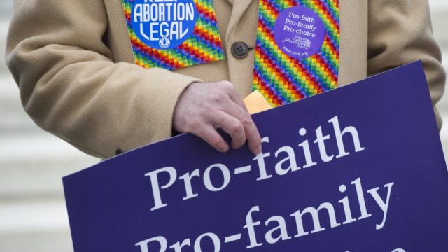 Pro-choice demonstrators stand outside the US Supreme Court following oral arguments in the case of McCullen v. Coakley, dealing with a Massachusetts law imposing a 35-foot buffer zone around abortion clinics for demonstrations and protests, in Washington, DC, January 15, 2014. An anti-abortion protestor, Eleanor McCullen of Newton, Massachusetts, argues that the 2007 state law restricts her free speech rights under the First Amendment, while the state and Planned Parenthood argue they provide protection for individuals going to the clinics and provide a way to maintain public safety. AFP PHOTO / Saul LOEB (Photo credit should read SAUL LOEB/AFP/Getty Images)